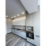 Светлая угловая кухня с высокими пеналами и встроенной духовкой
