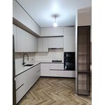 Угловая кухня в светло-серых тонах со стеклянным пеналом-витриной